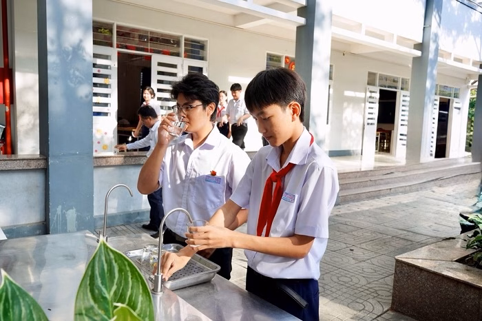 Các em học sinh sử dụng nước uống sau khi công trình “Nước sạch cho em” được bàn giao.